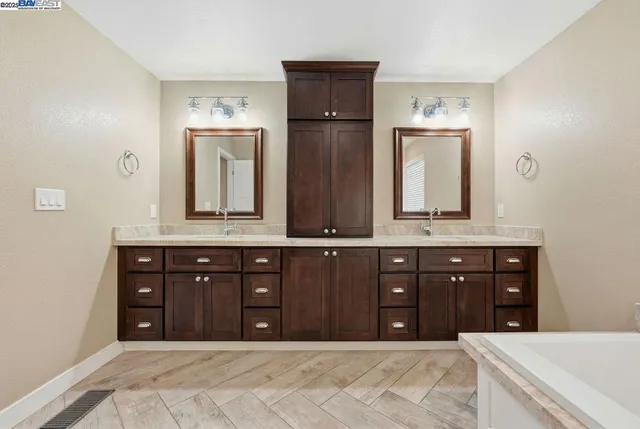 a bathroom with a tub sink and mirror