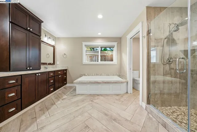a spacious bathroom with a tub sink shower and mirror