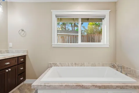 a bathroom with a tub sink and window