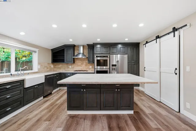 a kitchen with kitchen island granite countertop a sink appliances and cabinets