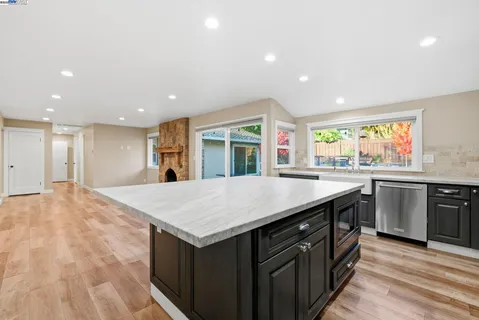 a kitchen with stainless steel appliances granite countertop a sink and large window