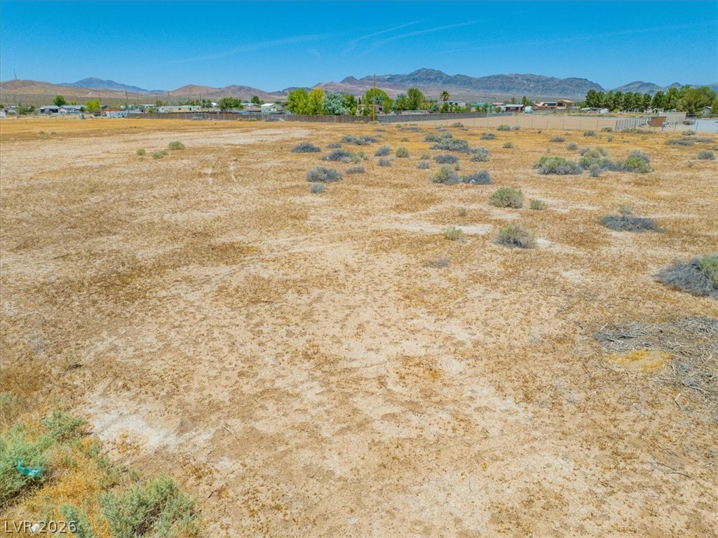 4610 Lawrence Road Pahrump, NV 89048 - Photo 18 of 42 Vast, buildable lot with desert vegetation and mountain backdrop, offering open skies and distant community views.