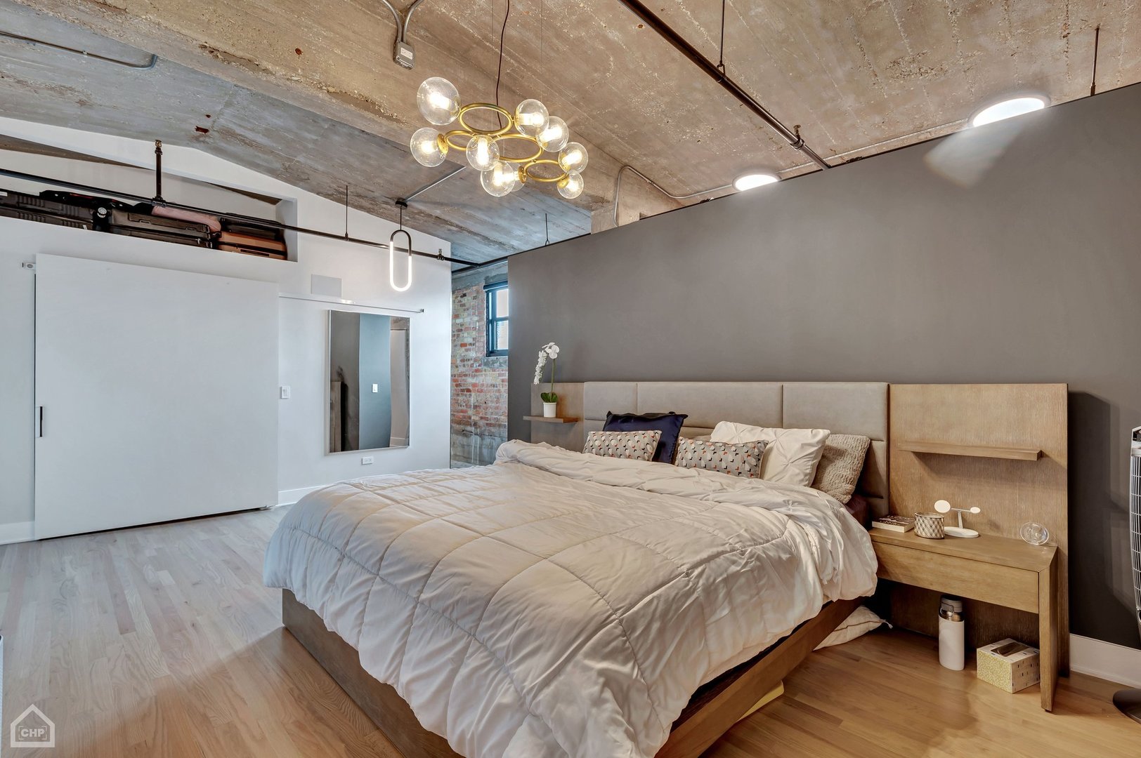 1017 West Washington Boulevard, Unit 7APH Chicago, IL 60607 - Photo 20 of 30 a bedroom with a large bed and a chandelier