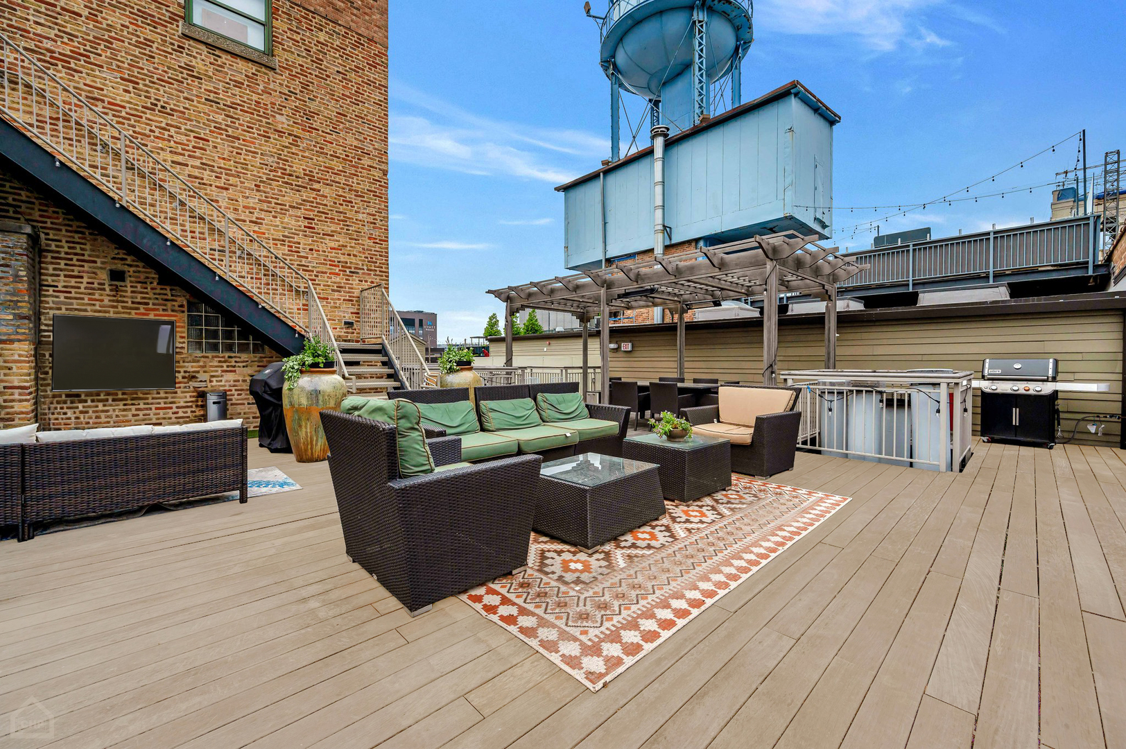 1017 West Washington Boulevard, Unit 7APH Chicago, IL 60607 - Photo 27 of 30 a view of a roof deck with couches wooden floor and fence