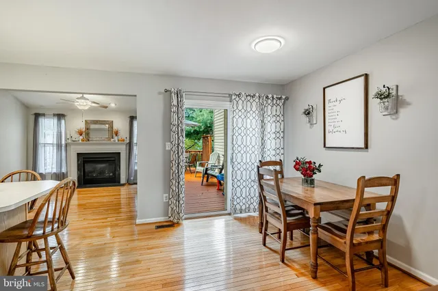 a dining room with furniture a fireplace and wooden floor