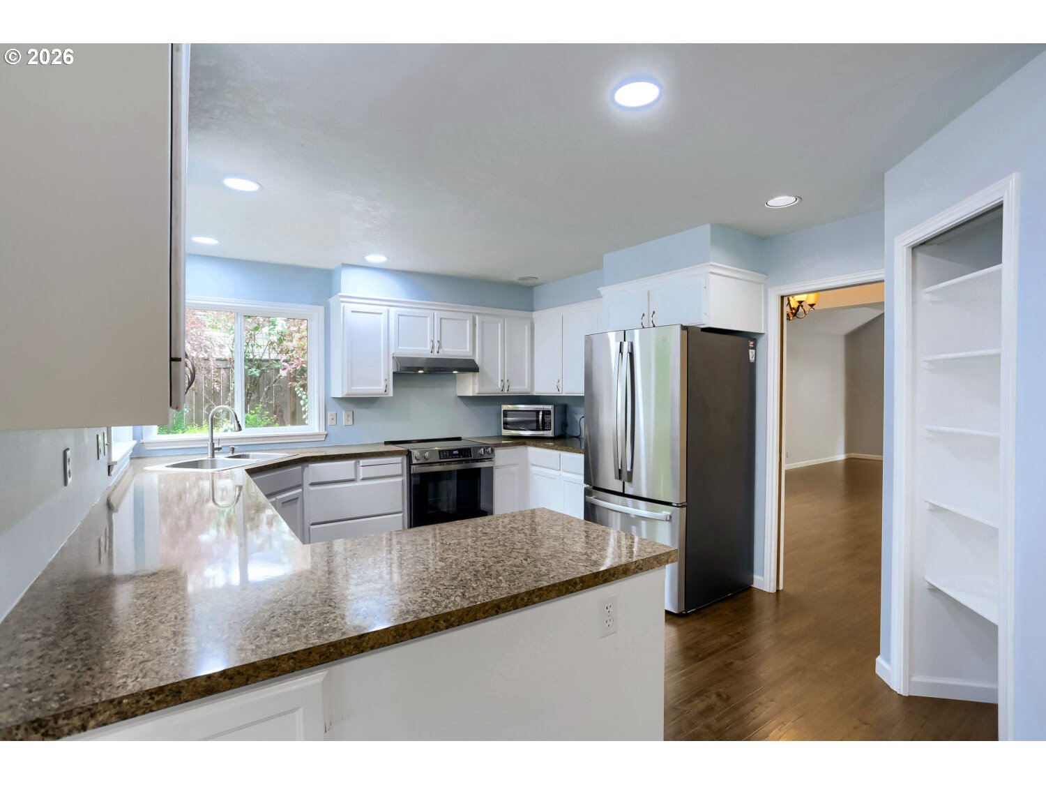 8160 Southwest 147th Terrace Beaverton, OR 97007 - Photo 12 of 31 a kitchen with stainless steel appliances granite countertop a refrigerator a sink a stove a microwave and island