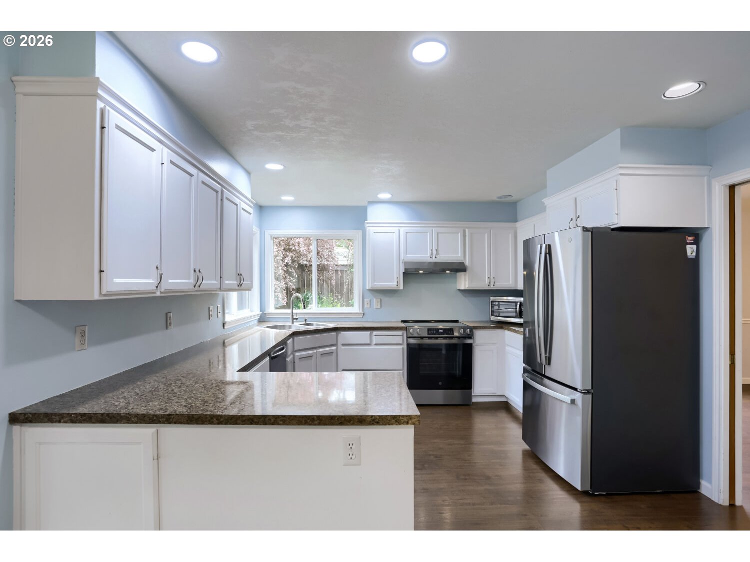 8160 Southwest 147th Terrace Beaverton, OR 97007 - Photo 13 of 31 a kitchen with stainless steel appliances granite countertop a refrigerator a sink a stove a microwave and island