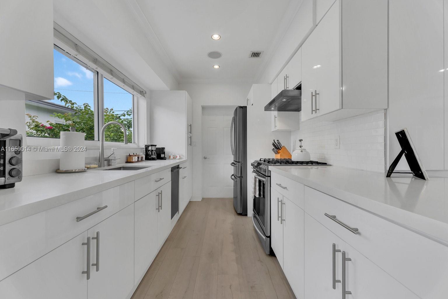 900 Surfside Boulevard Surfside, FL 33154 - Photo 17 of 38 a kitchen with stainless steel appliances a sink stove and cabinets