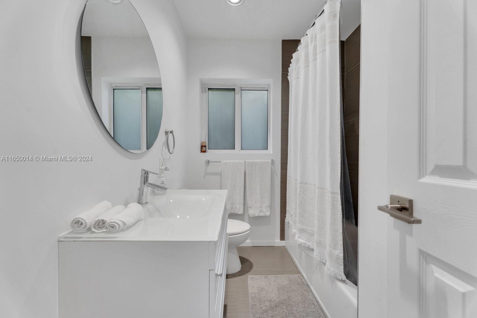 900 Surfside Boulevard Surfside, FL 33154 - Photo 22 of 38 a bathroom with a sink a toilet and shower