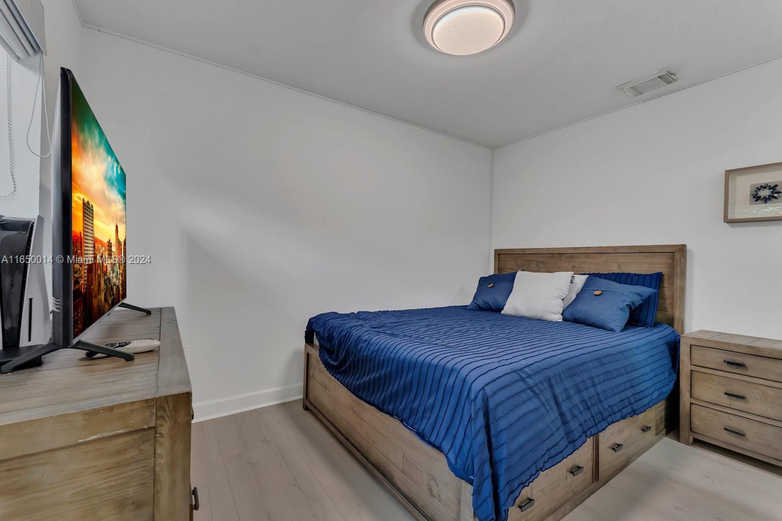 900 Surfside Boulevard Surfside, FL 33154 - Photo 27 of 38 a bedroom with a bed and a flat tv screen on dresser