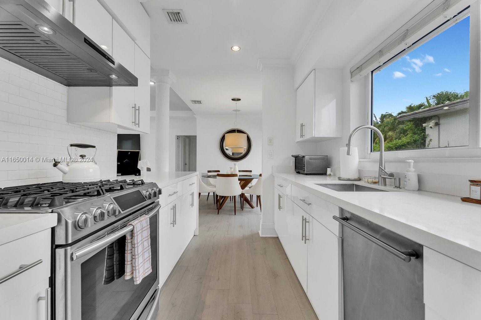 900 Surfside Boulevard Surfside, FL 33154 - Photo 3 of 38 a kitchen with a sink stove and cabinets