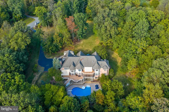 an aerial view of a house with a yard and lake view