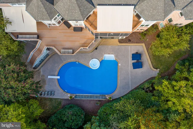 an aerial view of a house with swimming pool and outdoor seating