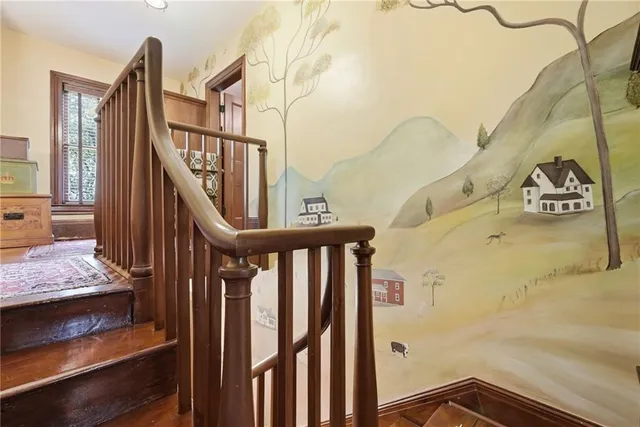 a view of staircase with railing and white walls