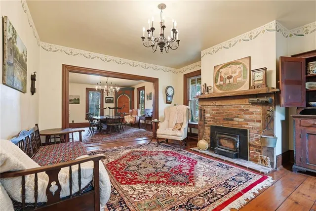 a living room with furniture a fireplace and a chandelier