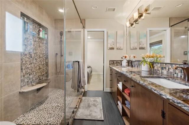 a spacious bathroom with a granite countertop sink a toilet and a mirror