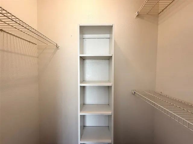 a view of walk in closet with empty racks