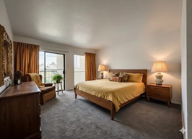 a bedroom with a bed and large windows