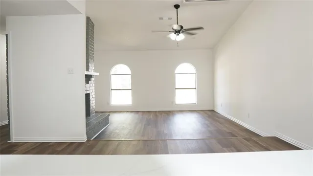an empty room with a window and a ceiling fan