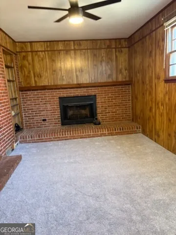 a view of an empty room with a fireplace and a window