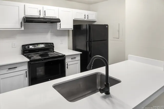 a kitchen with a stove cabinets and a refrigerator