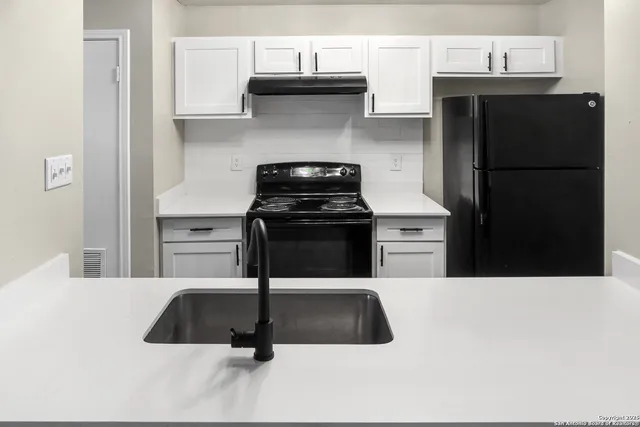 a kitchen with a sink a stove and refrigerator