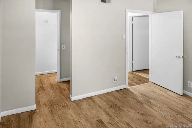 a view of an empty room with wooden floor