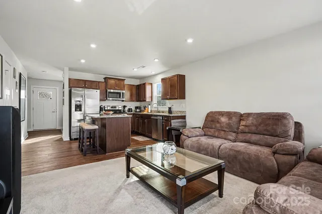 a living room with furniture and kitchen view