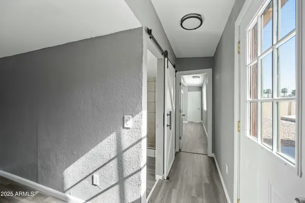 a view of a hallway with wooden floor and staircase