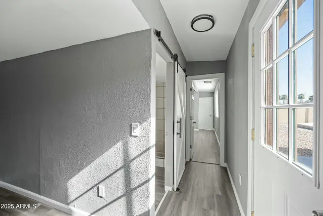 a view of a hallway with wooden floor and staircase