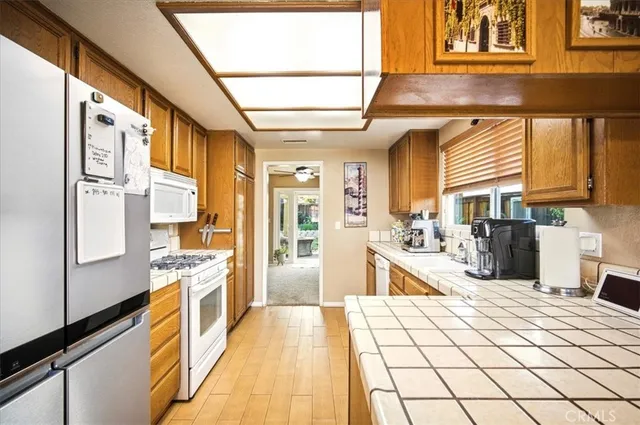 a large kitchen with stainless steel appliances kitchen island granite countertop a large window