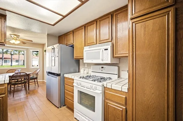 a kitchen with stainless steel appliances granite countertop a refrigerator and a stove top oven