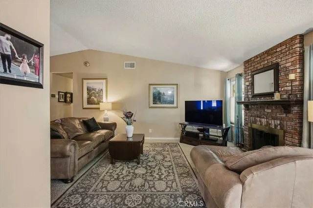 a living room with furniture a fireplace and a flat screen tv