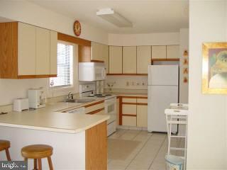 0 Edward Taylor Road, Unit 904 Ocean City, MD 21842 - Photo 2 of 3 a kitchen with a stove a refrigerator and white cabinets