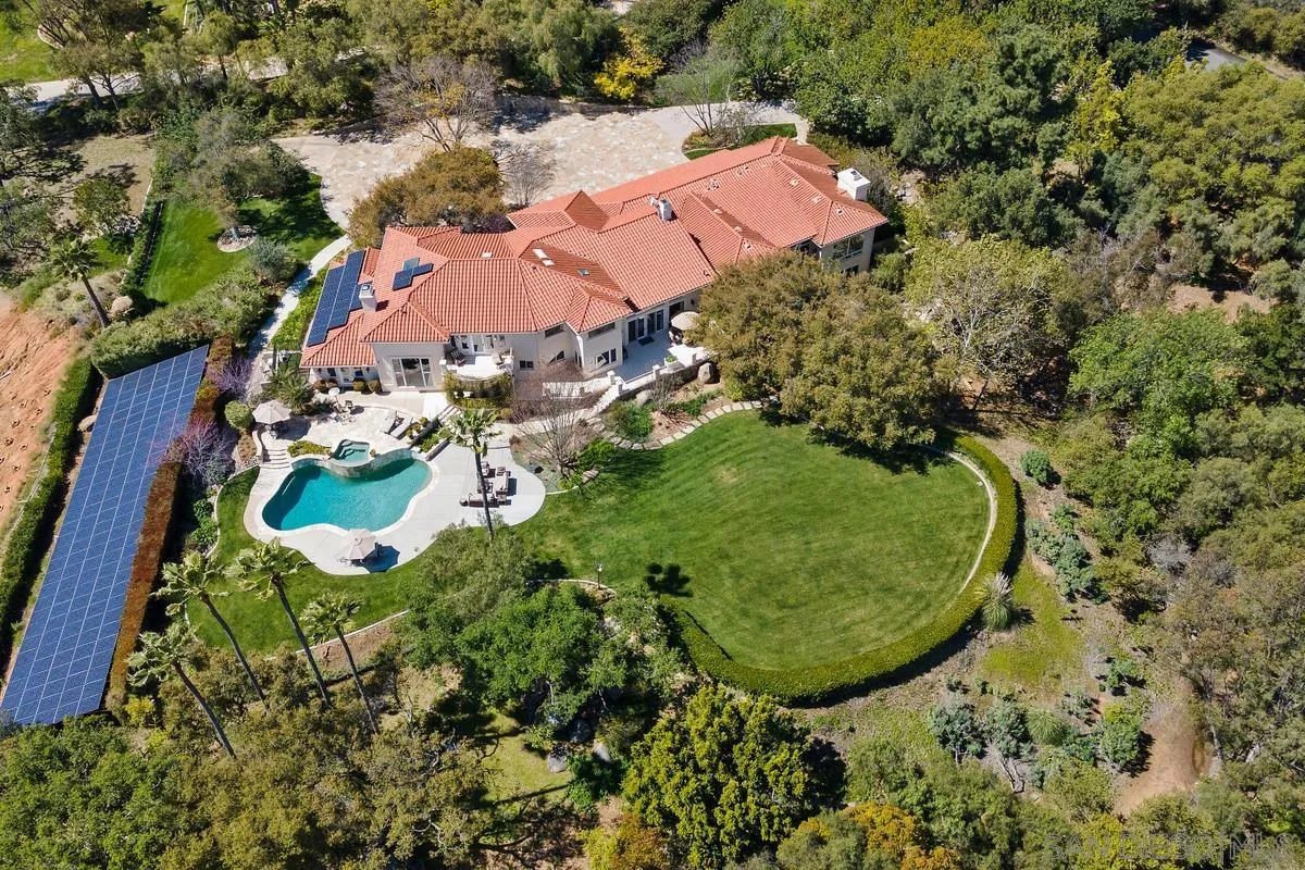 an aerial view of a house with a garden and lake view