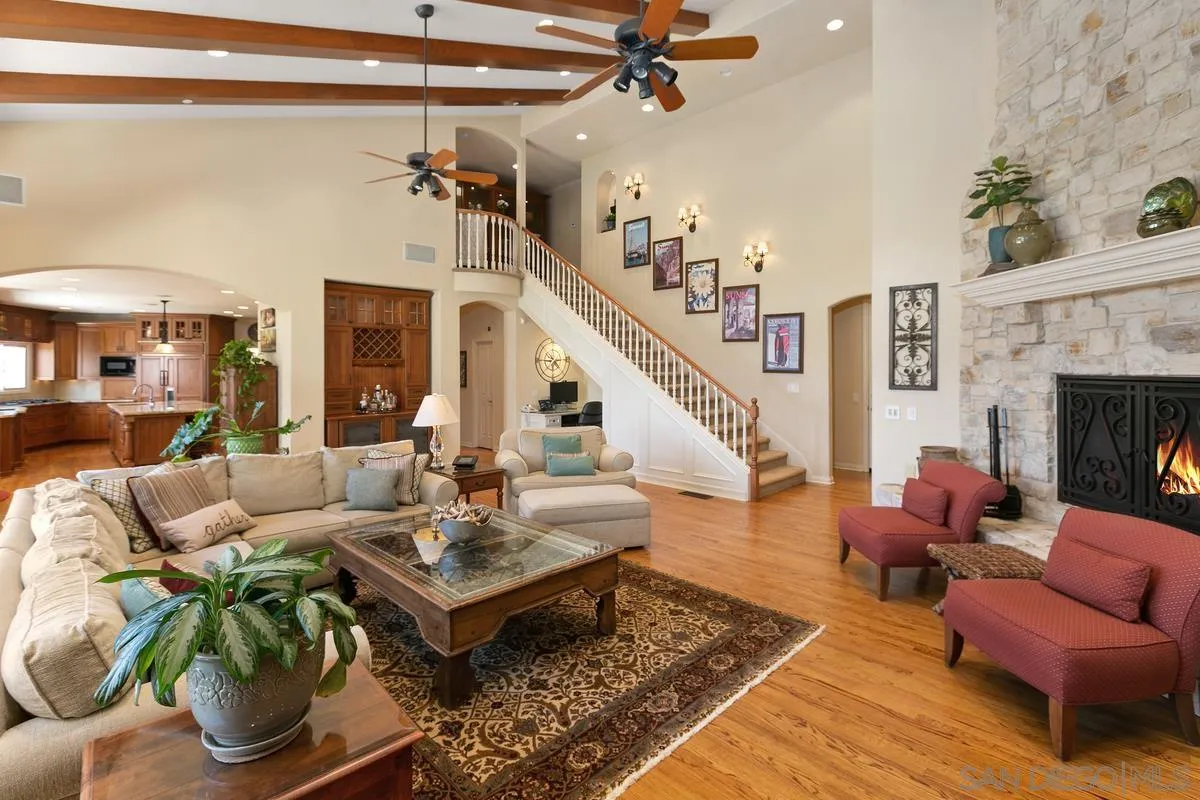 15629 Boulder Mountain Road Poway, CA 92064 - Photo 18 of 64 a living room with furniture a fireplace and a chandelier