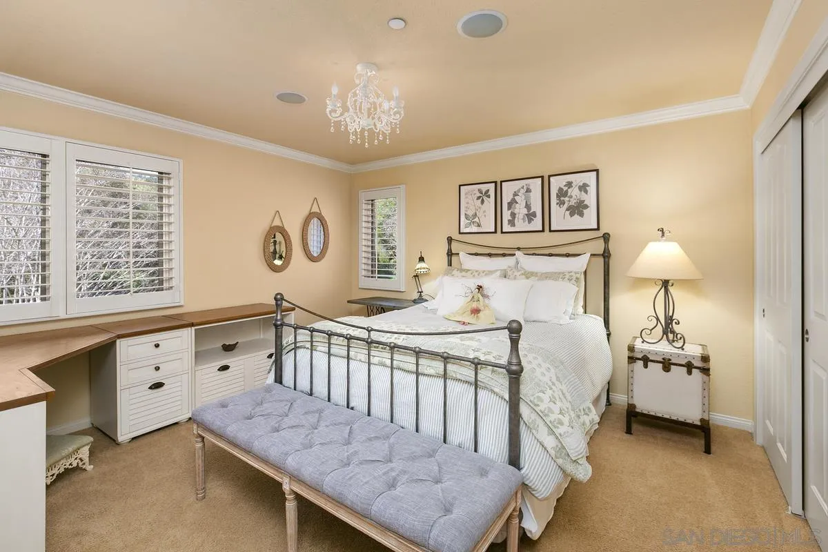 15629 Boulder Mountain Road Poway, CA 92064 - Photo 25 of 64 a bedroom with a bed and a chandelier