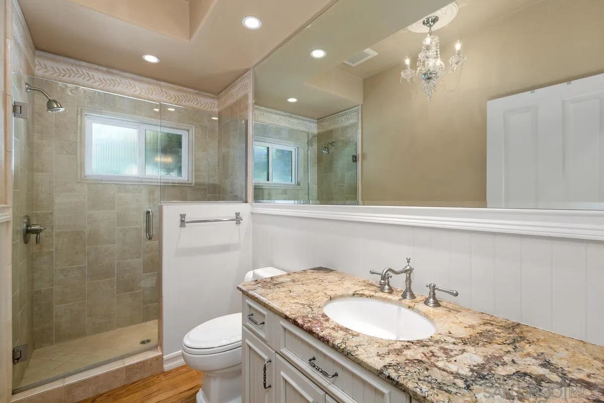 15629 Boulder Mountain Road Poway, CA 92064 - Photo 31 of 64 a bathroom with a granite countertop sink a toilet a mirror and shower