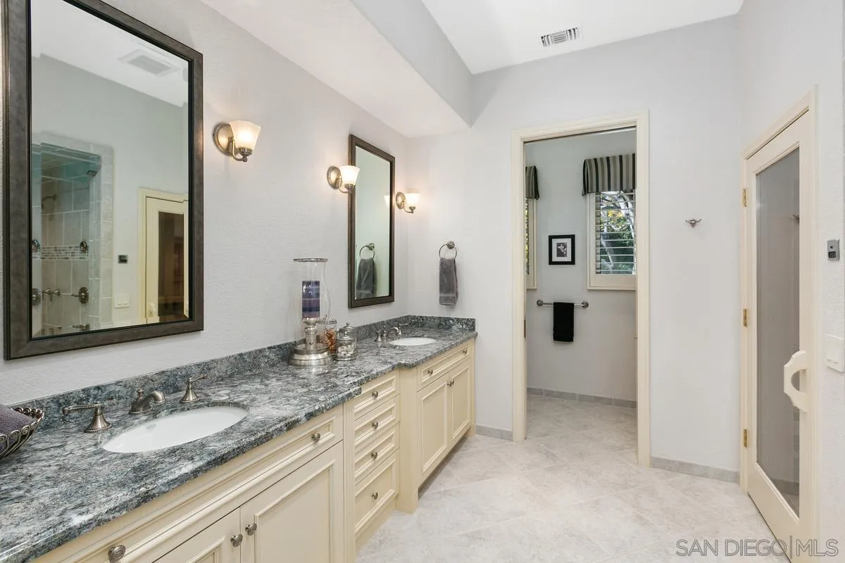 15629 Boulder Mountain Road Poway, CA 92064 - Photo 35 of 64 a bathroom with a granite countertop sink and a mirror