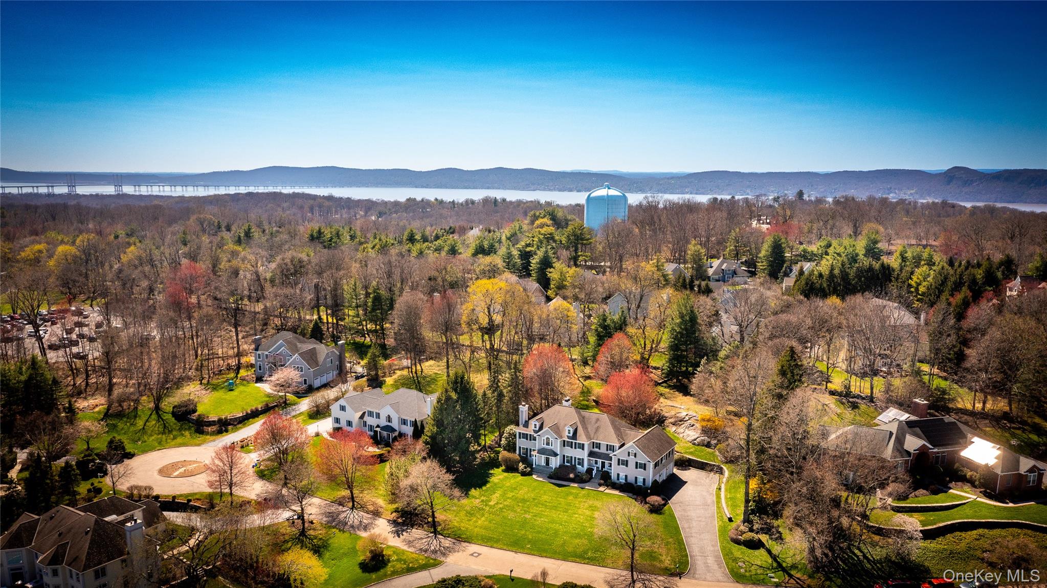 Aerial perspective of suburban area featuring a forest and a water and mountain view