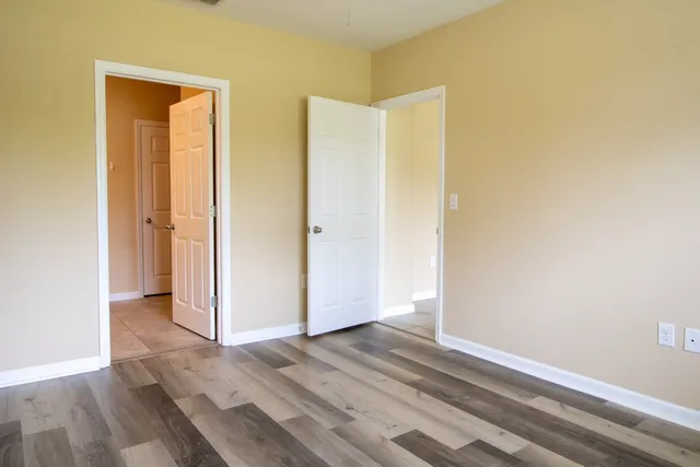 an empty room with wooden floor and closet