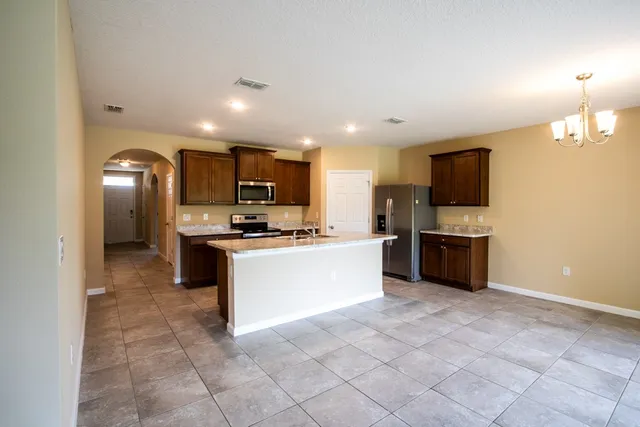 a large kitchen with a large counter top appliances and cabinets