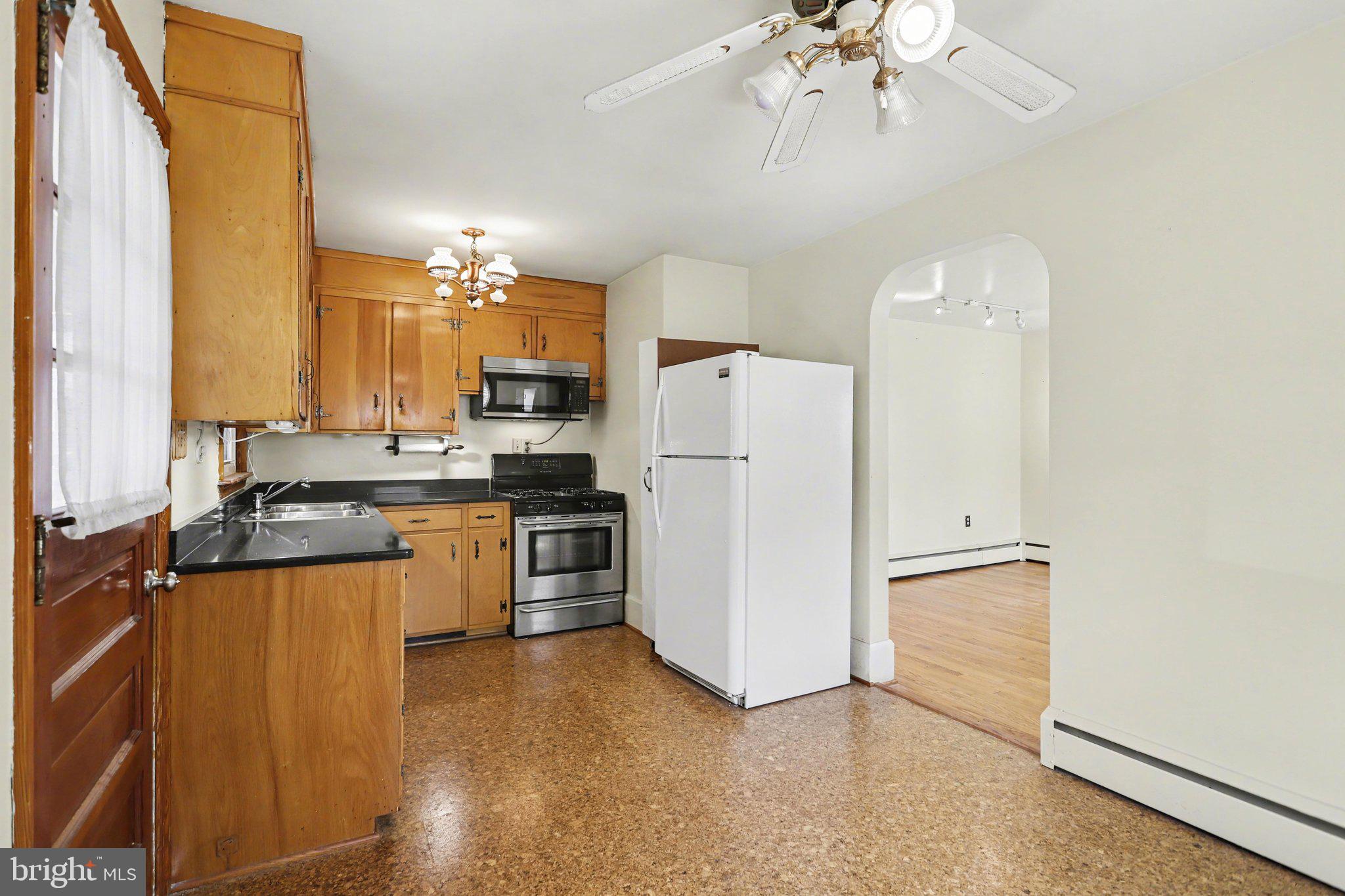 932 East Walnut Street Hanover, PA 17331 - Photo 9 of 44 a kitchen with granite countertop a refrigerator a sink dishwasher a stove and a dining table with wooden floor