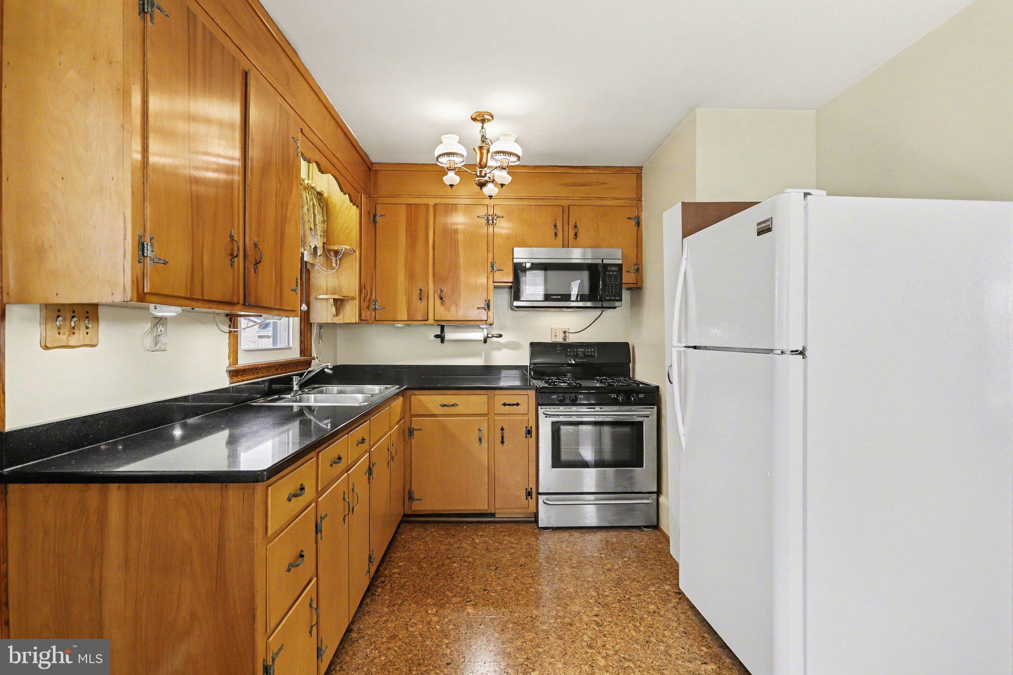 932 East Walnut Street Hanover, PA 17331 - Photo 10 of 44 a kitchen with stainless steel appliances granite countertop a refrigerator a sink dishwasher a stove with white cabinets and wooden floor