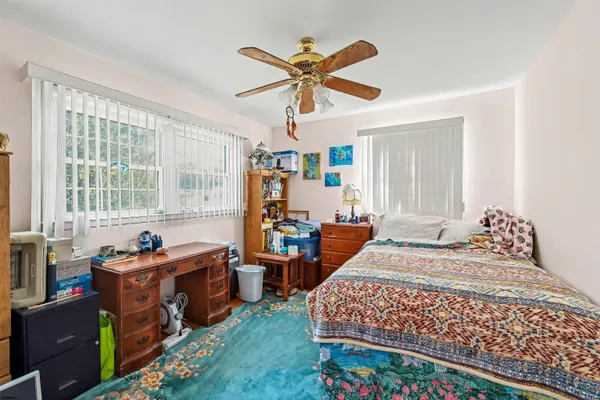 a bedroom with a bed and a large window