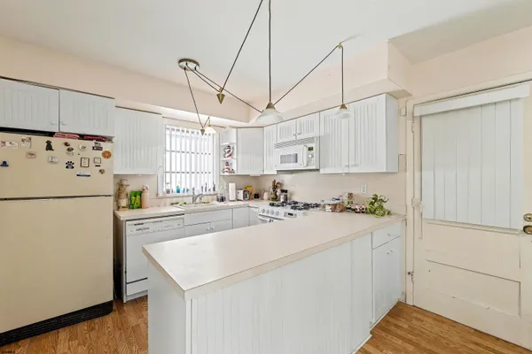 a kitchen with refrigerator and white cabinets