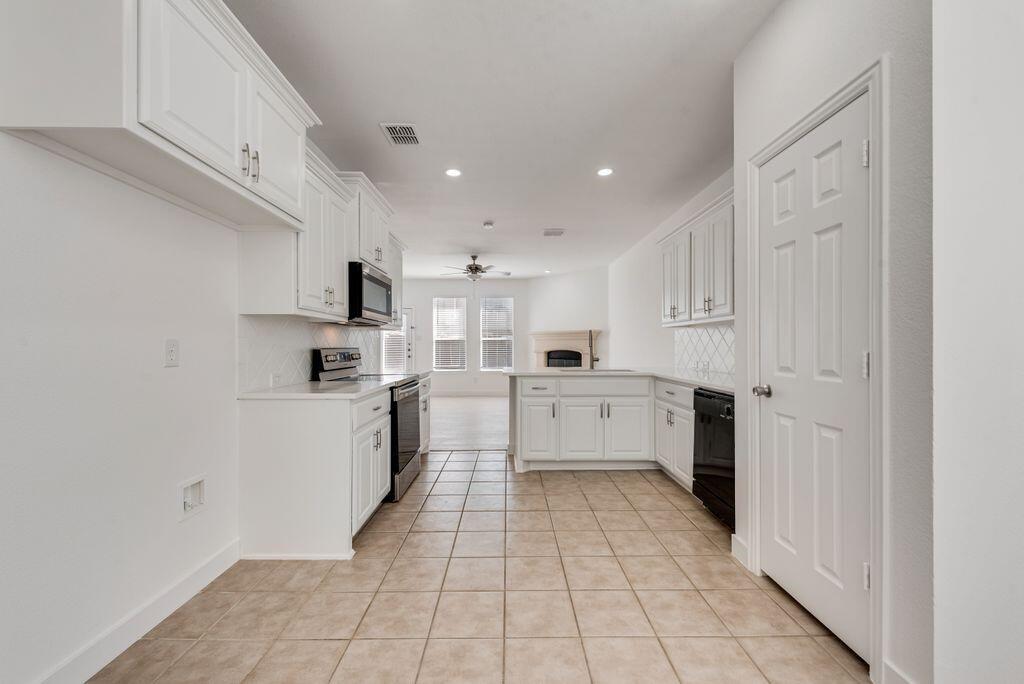 2640 Lake Ridge Drive Little Elm, TX 75068 - Photo 5 of 15 a kitchen with white cabinets and white appliances