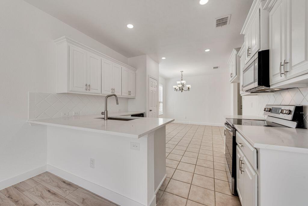 2640 Lake Ridge Drive Little Elm, TX 75068 - Photo 6 of 15 a kitchen with stainless steel appliances a sink a stove a microwave a sink a refrigerator and cabinets