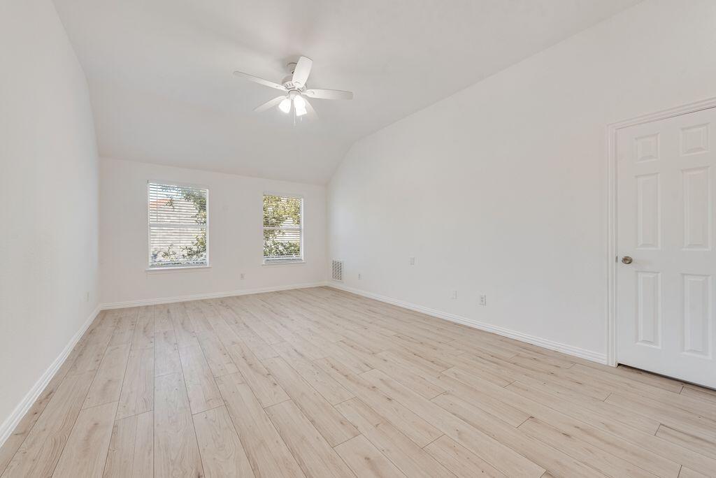 2640 Lake Ridge Drive Little Elm, TX 75068 - Photo 10 of 15 an empty room with wooden floor chandelier fan and windows