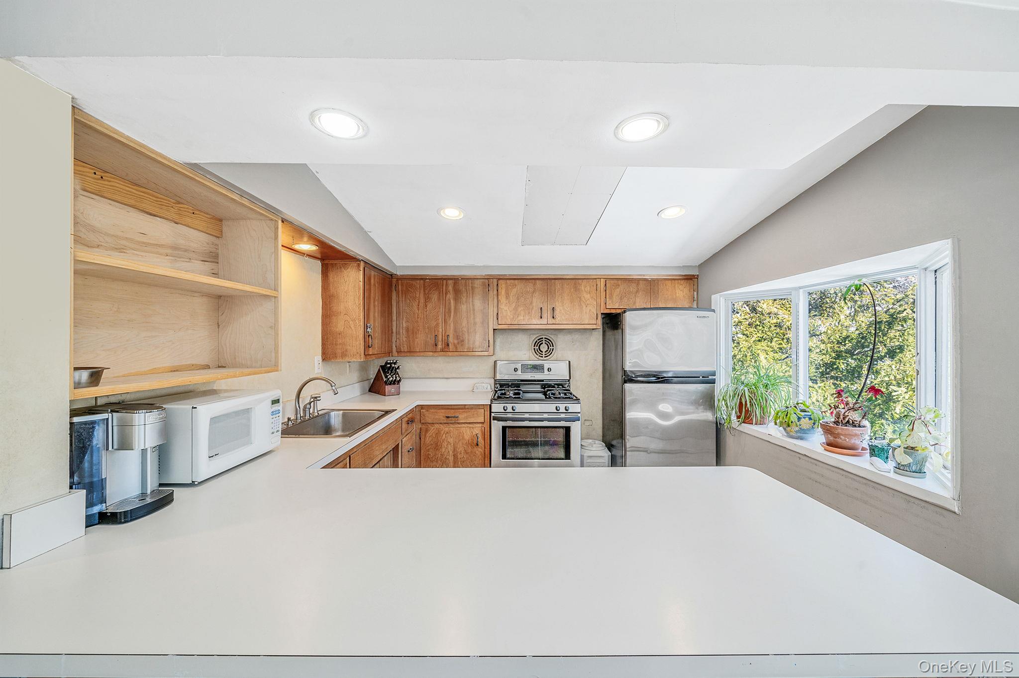 15 Ridge Lane Miller Place, NY 11764 - Photo 9 of 26 a kitchen with appliances a sink and a counter top space